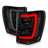 ANZO 1999-2004 Jeep Grand Cherokee LED Tail Light Set with Light Bar and Smoke Lens - Black Housing